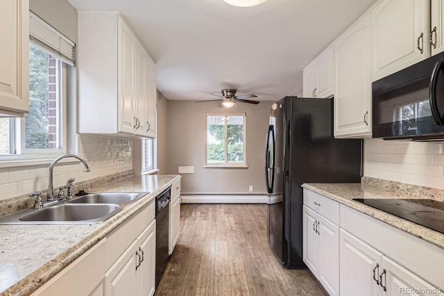 1824 S Columbine St, Denver, CO 80210 - kitchen with black appliances, a sink, baseboard heating, dark wood-style floors, and white cabinets