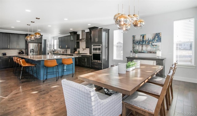 dining space featuring recessed lighting, dark wood finished floors, baseboards, and an inviting chandelier