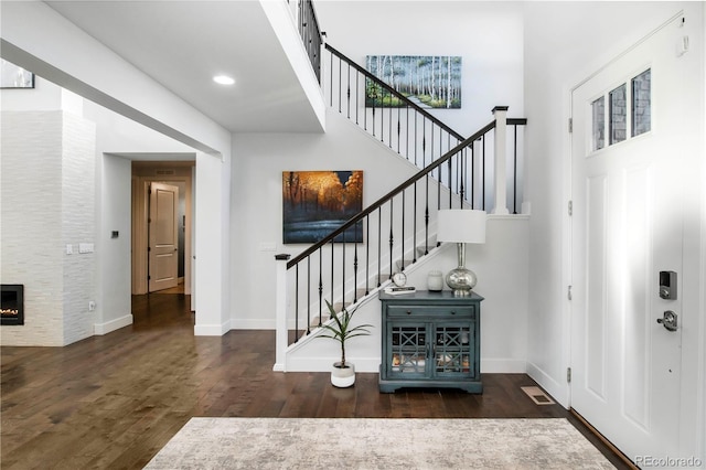 entryway featuring stairway, wood finished floors, visible vents, and baseboards