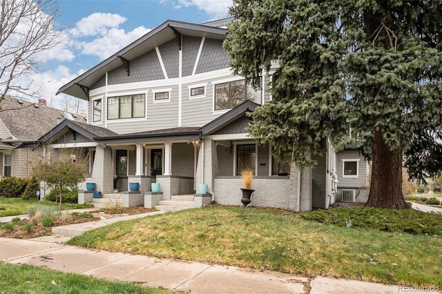 1401 S Clarkson St, Denver, CO 80210 - craftsman house featuring covered porch, brick siding, a front yard, and central AC