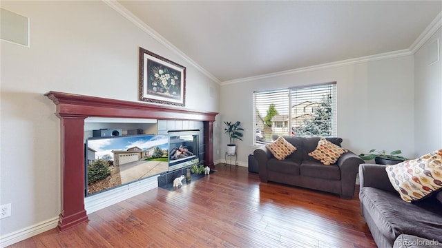 living room featuring hardwood / wood-style floors, lofted ceiling, crown molding, and a fireplace