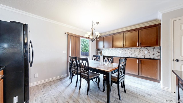 dining space with ornamental molding, light hardwood / wood-style floors, and a chandelier