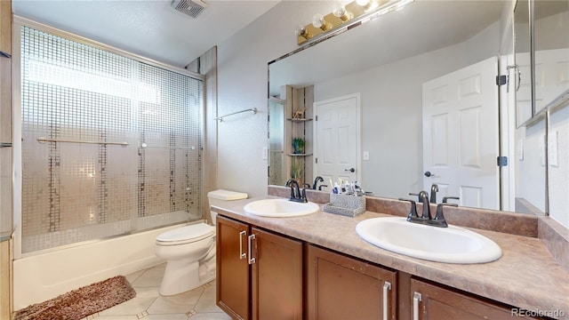 full bathroom with large vanity, toilet, combined bath / shower with glass door, double sink, and tile floors