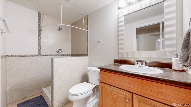 bathroom featuring tile flooring, oversized vanity, tile walls, and toilet