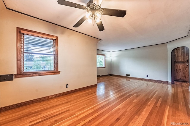1325 N Foote Ave, Colorado Springs, CO 80909 - empty room featuring arched walkways, light wood-style floors, ceiling fan, and baseboards