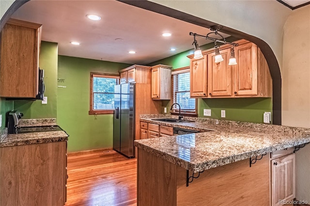 1325 N Foote Ave, Colorado Springs, CO 80909 - kitchen featuring a sink, stainless steel fridge with ice dispenser, range, a kitchen breakfast bar, and light wood finished floors