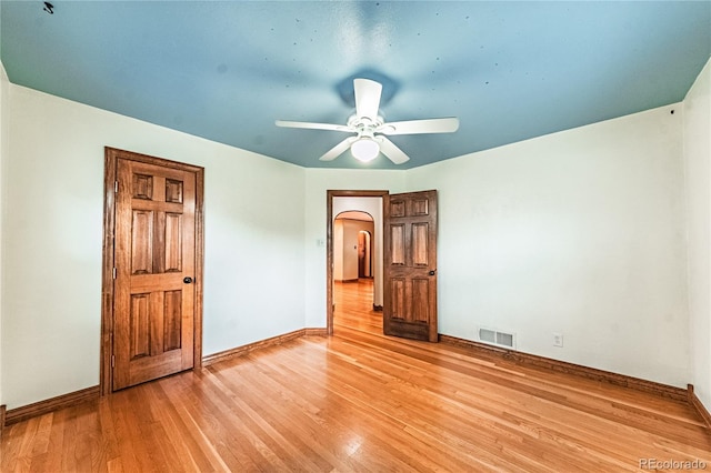 1325 N Foote Ave, Colorado Springs, CO 80909 - unfurnished bedroom with arched walkways, light wood-style flooring, and baseboards