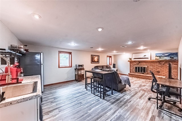 1325 N Foote Ave, Colorado Springs, CO 80909 - living room with light wood-type flooring, baseboards, a fireplace, and recessed lighting