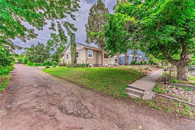 1325 N Foote Ave, Colorado Springs, CO 80909 - view of home's exterior featuring stucco siding, a lawn, and a chimney