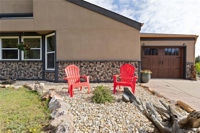 1819 Nova Rd, Pine, CO 80470 - view of home's exterior featuring stone siding, driveway, an attached garage, and stucco siding