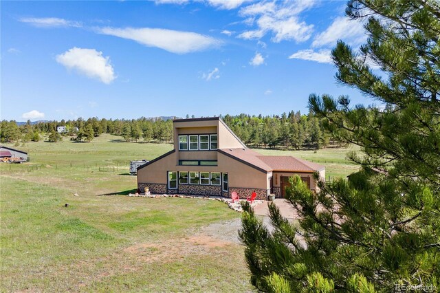 1819 Nova Rd, Pine, CO 80470 - view of front facade featuring stucco siding, an attached garage, stone siding, dirt driveway, and a front yard