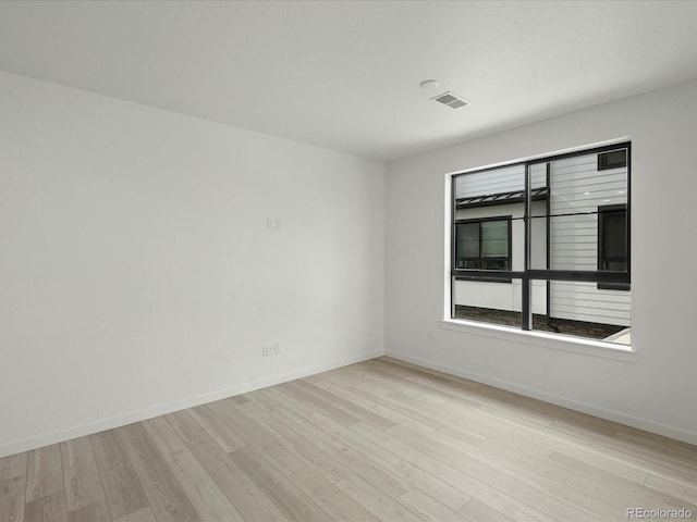 unfurnished room with visible vents, baseboards, and wood finished floors