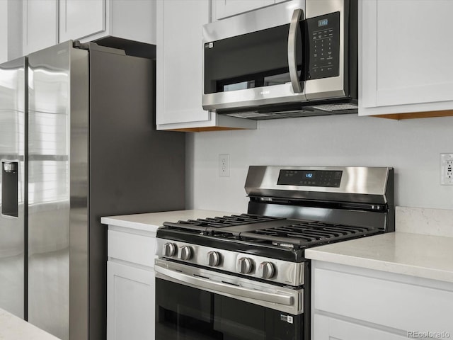 kitchen featuring stainless steel appliances and white cabinets