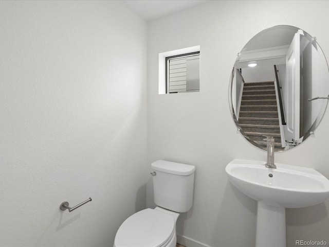 bathroom featuring toilet and baseboards