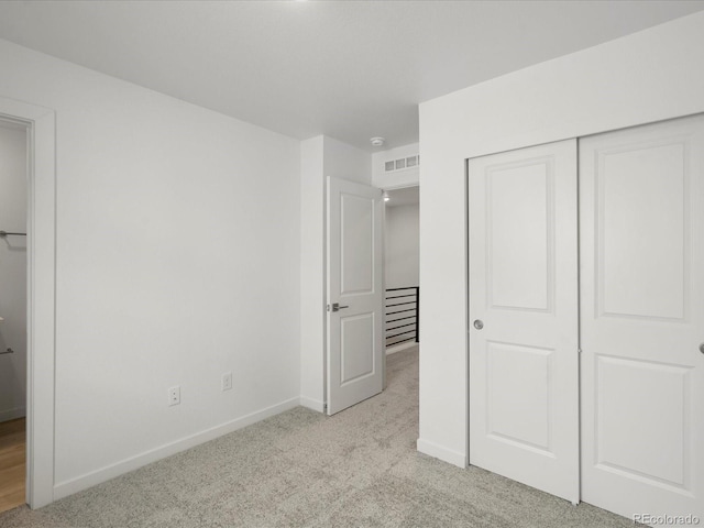 unfurnished bedroom with light carpet, a closet, visible vents, and baseboards