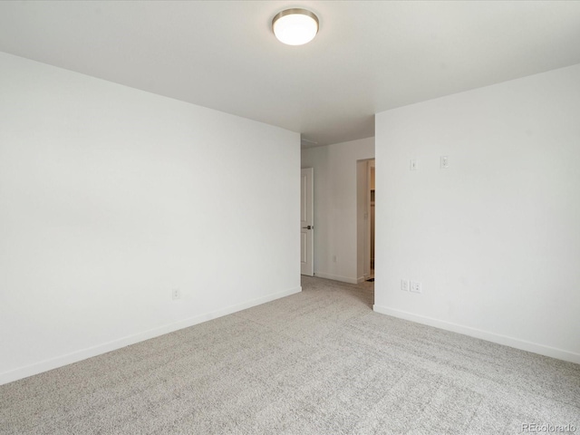 unfurnished room with baseboards and light colored carpet