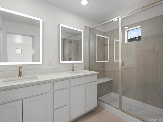 full bath with double vanity, a shower stall, and a sink