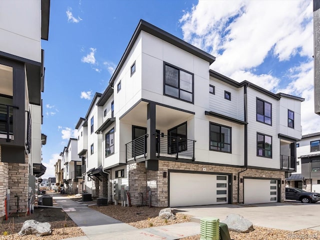 2036 S Holly St Unit 4, Denver, CO 80222 - view of property with central air condition unit, a residential view, driveway, stone siding, and a garage