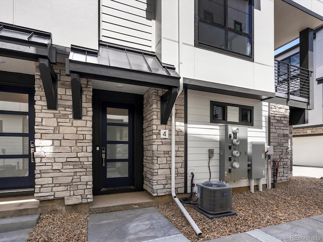 2036 S Holly St Unit 4, Denver, CO 80222 - doorway to property with stone siding and cooling unit