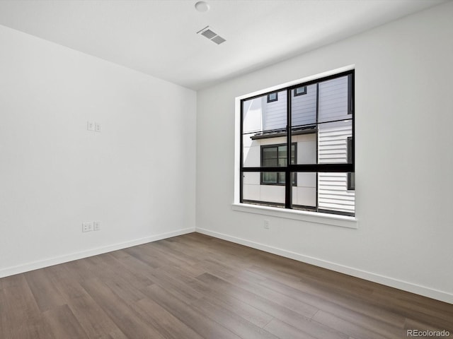 2036 S Holly St Unit 4, Denver, CO 80222 - spare room with wood finished floors, a healthy amount of sunlight, and baseboards