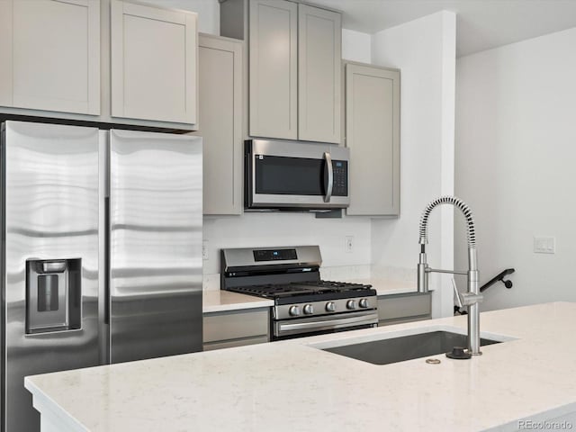 2036 S Holly St Unit 4, Denver, CO 80222 - kitchen with light stone counters, appliances with stainless steel finishes, gray cabinetry, and a sink