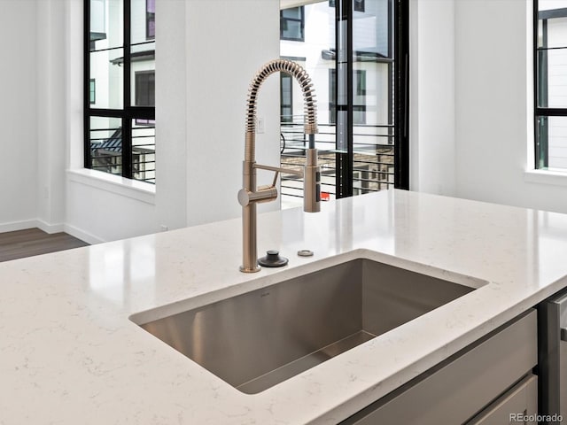2036 S Holly St Unit 4, Denver, CO 80222 - interior details with baseboards, light stone counters, and a sink
