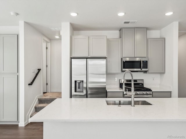 2036 S Holly St Unit 4, Denver, CO 80222 - kitchen featuring light stone counters, visible vents, a sink, gray cabinetry, and appliances with stainless steel finishes
