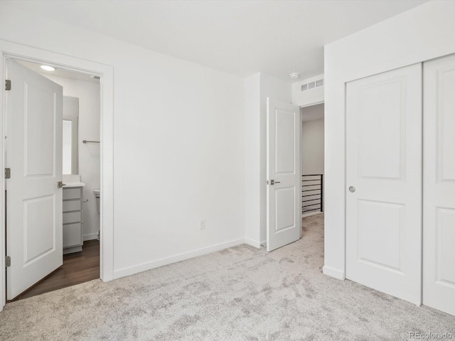 2036 S Holly St Unit 4, Denver, CO 80222 - unfurnished bedroom with ensuite bath, carpet floors, a closet, and baseboards