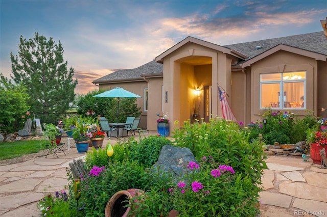 view of front of home featuring stucco siding and a patio