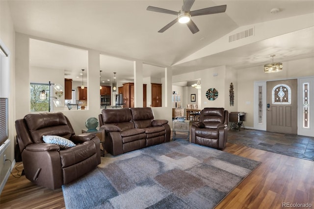 living room featuring dark wood-style flooring, vaulted ceiling, and a ceiling fan