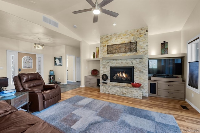 living area with built in features, lofted ceiling, wood finished floors, a ceiling fan, and baseboards
