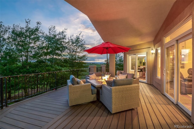 deck featuring an outdoor living space with a fire pit