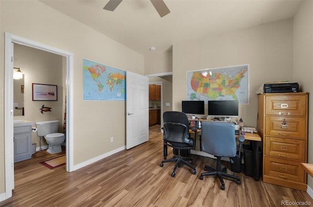 office space featuring light wood-style flooring, a ceiling fan, and baseboards