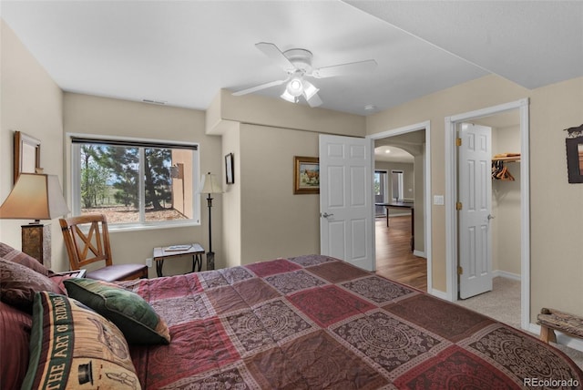bedroom featuring arched walkways, baseboards, and ceiling fan