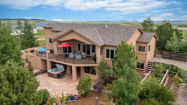 back of property with a patio, stucco siding, a shingled roof, and a wooden deck