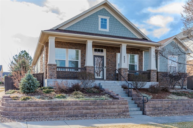 craftsman house featuring stone siding and a porch