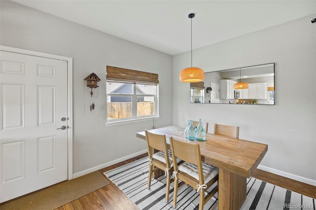 dining space with wood finished floors and baseboards