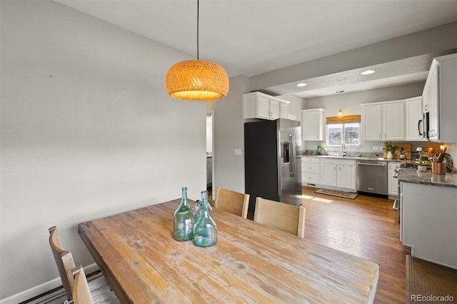 dining space with recessed lighting, wood finished floors, and baseboards