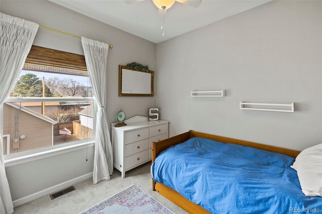 bedroom with a ceiling fan, light colored carpet, visible vents, and baseboards