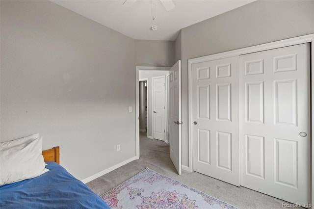 bedroom featuring a closet, baseboards, a ceiling fan, and light colored carpet