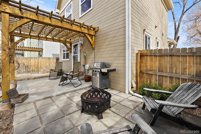 view of patio featuring a fire pit, grilling area, a fenced backyard, and a pergola