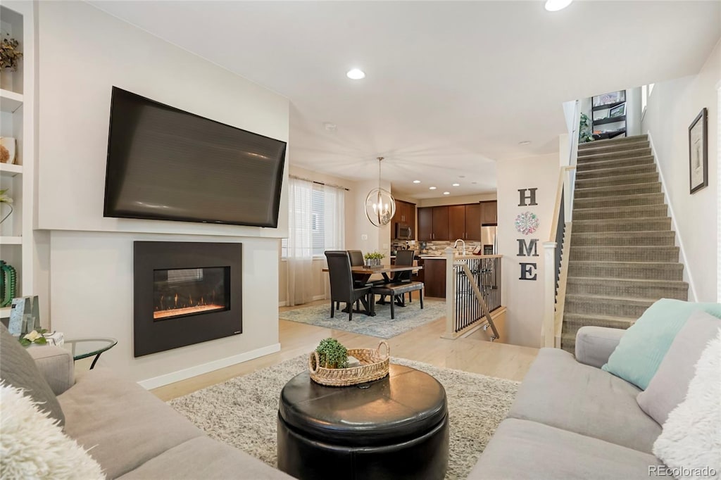 living room featuring light hardwood / wood-style flooring and a notable chandelier