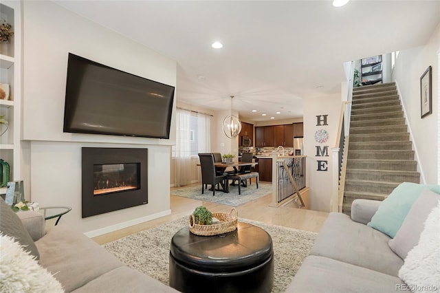 living room featuring light hardwood / wood-style flooring and a notable chandelier