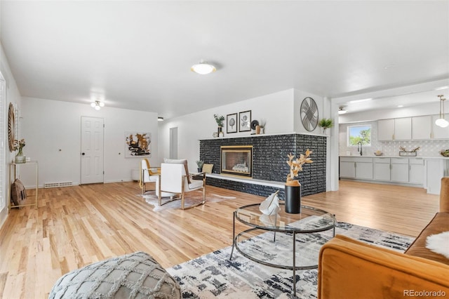 2180 Myrtlewood Ln, Lakewood, CO 80215 - living area with light wood-style floors and a brick fireplace