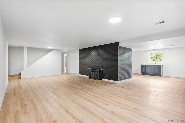 2180 Myrtlewood Ln, Lakewood, CO 80215 - unfurnished living room featuring light wood-style flooring and a wood stove