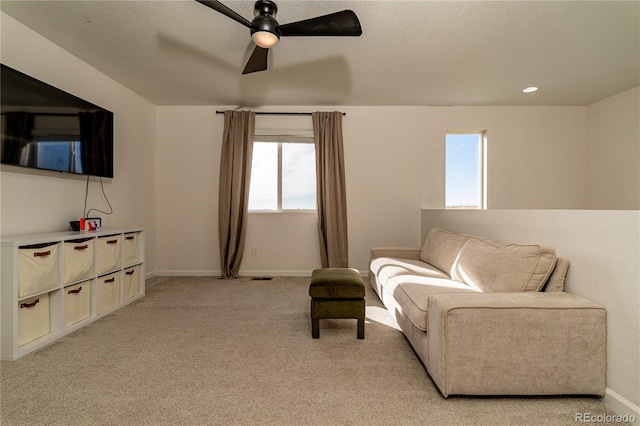 sitting room with ceiling fan and light carpet