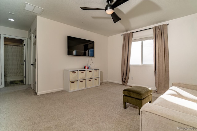 living room featuring a textured ceiling, light colored carpet, and ceiling fan