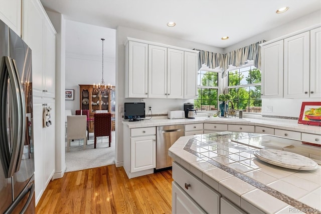 9411 E Hidden Hill Ln, Lone Tree, CO 80124 - kitchen with stainless steel appliances, tile countertops, a chandelier, white cabinetry, and recessed lighting
