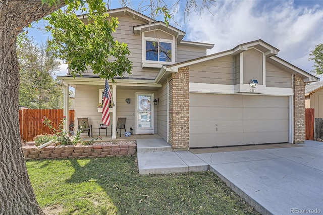 view of front of property featuring a front lawn, covered porch, and a garage