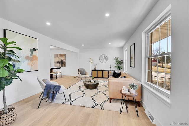 living area with baseboards, wood finished floors, visible vents, and recessed lighting